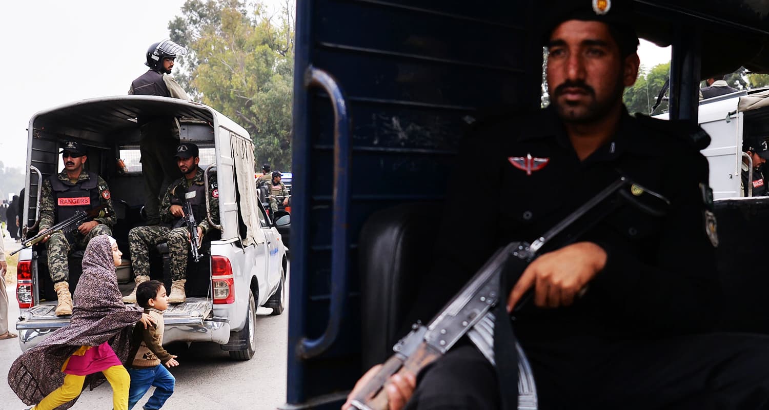 Children walk among the security vehicles protecting the funeral procession in Islamabad. — AFP