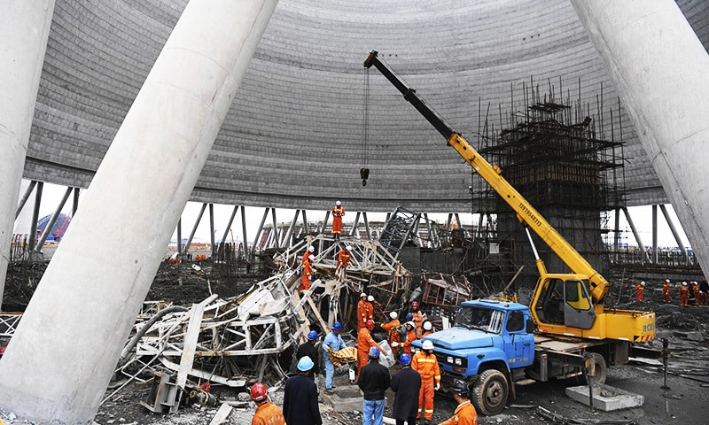In this photo released by Xinhua News Agency, rescue workers look for survivors after a work platform collapsed at the Fengcheng power plant in eastern China's Jiangxi Province.&mdash;Xinhua via AP
