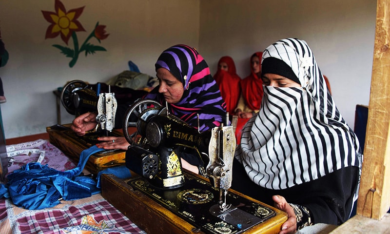 Kashmiri girls stitching cloth during their class in the women's market.—AFP