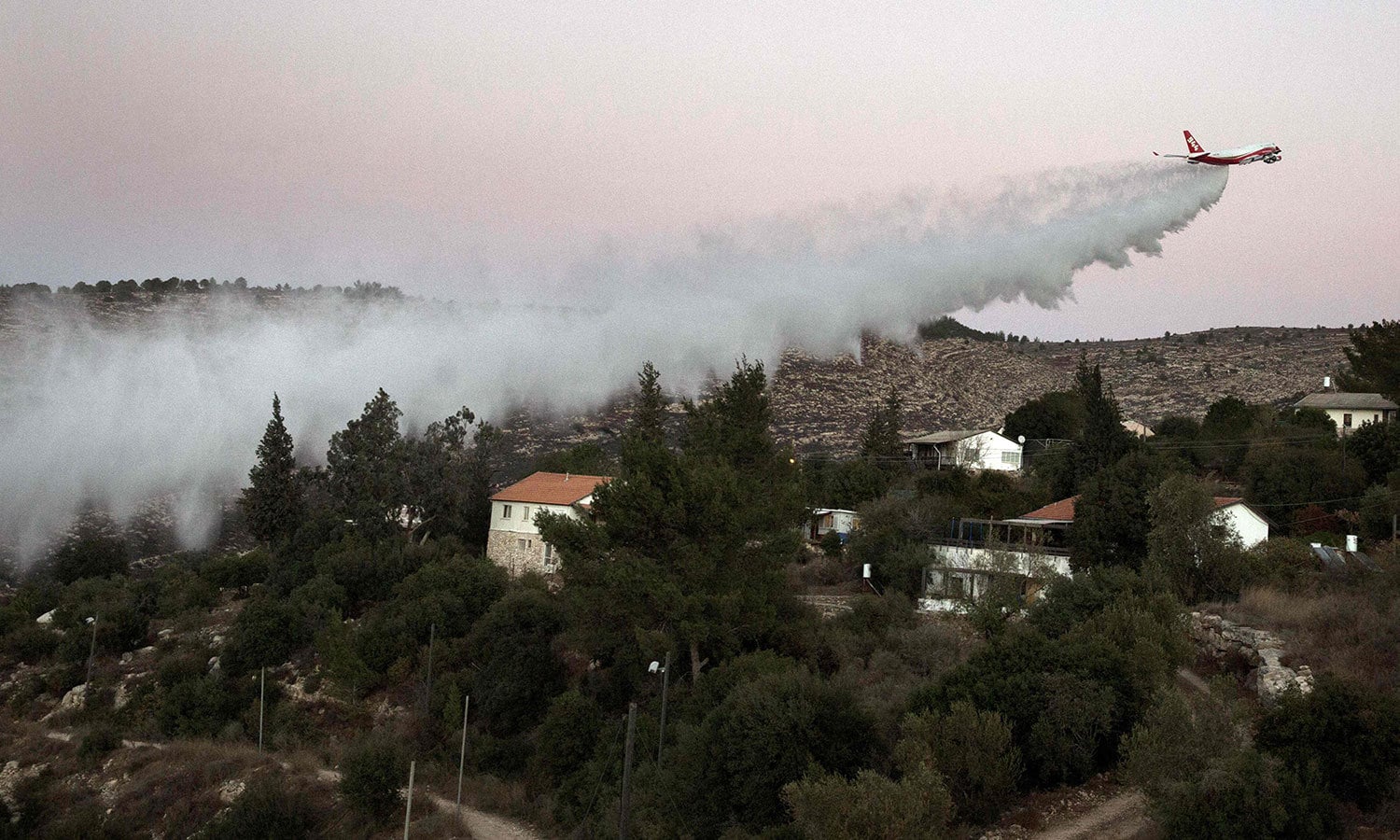 آگ بجھانے کیلئے طیارے کی مدد سے پانی ڈالا جارہا ہے &mdash; فوٹو: اے ایف پی