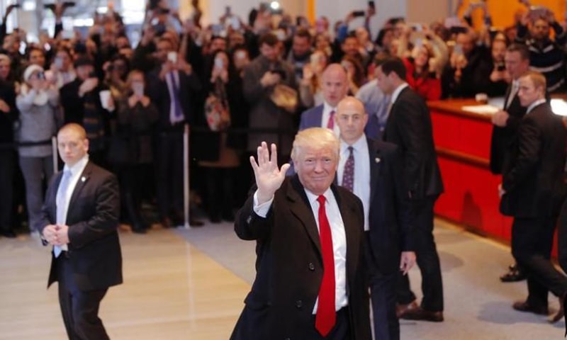 US President elect Donald Trump reacts to a crowd gathered in the lobby of the New York Times building after a meeting in New York, US &mdash; Reuters