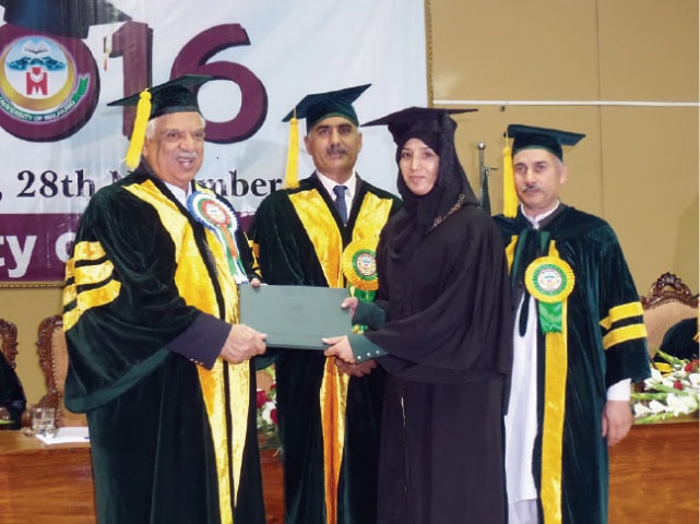 Governor Iqbal Zafar Jhagra awards degree to a graduate at the convocation of University of Malakand on Monday. &mdash; Dawn