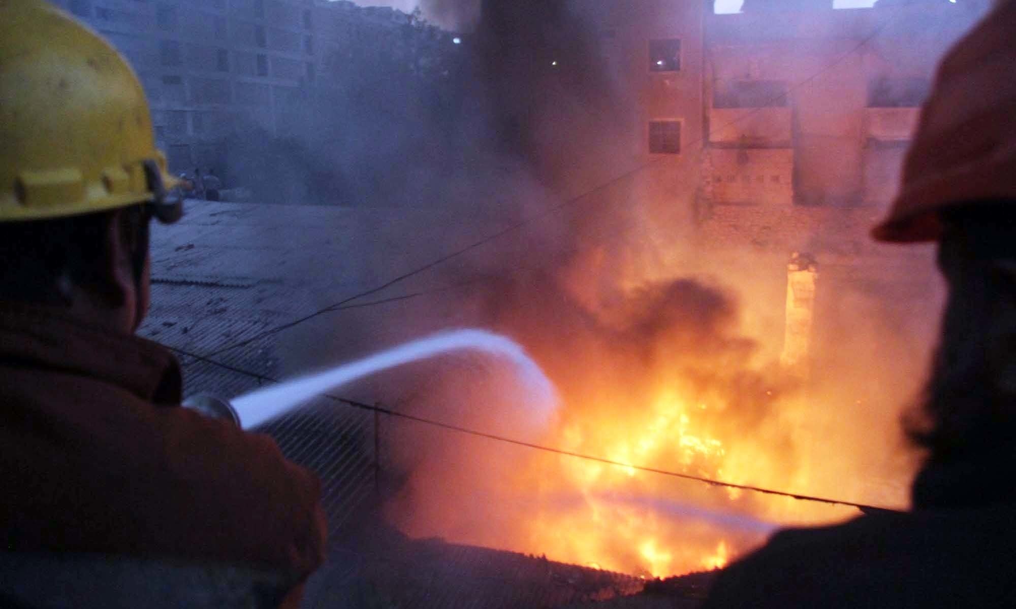 فائر فائٹر کا اہلکار کیمکل کے گودام میں لگی آگ بجھانے کی کوشش کرریا ہے — فوٹو: پی پی آئی فائر فائٹر کا اہلکار کیمکل کے گودام میں لگی آگ بجھانے کی کوشش کرریا ہے — فوٹو: پی پی آئی