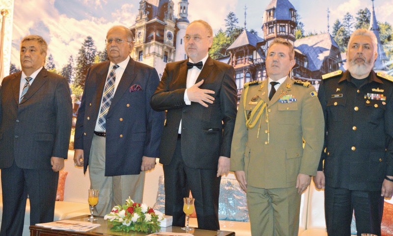 Minister for Interprovincial Cooperation Riaz Hussain Pirzada, Romanian ambassador Nicolae Goia and others listen to the national anthem of Romania.