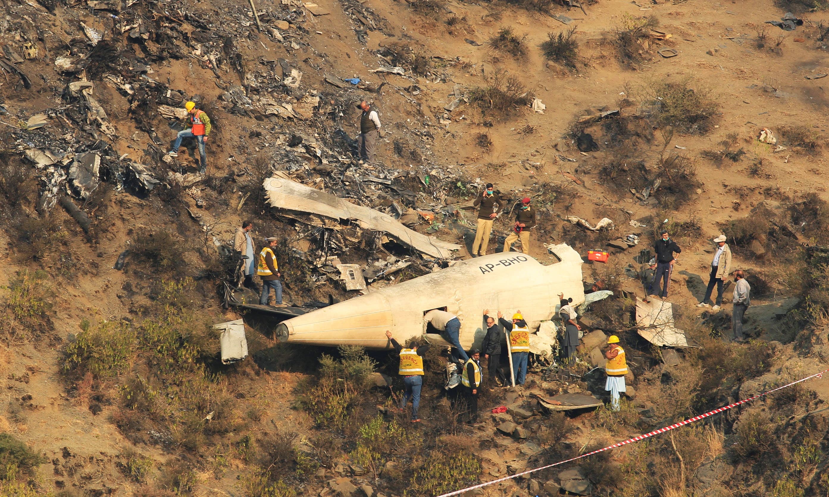 Rescue workers survey the site of a plane crashed a day earlier. — Reuters