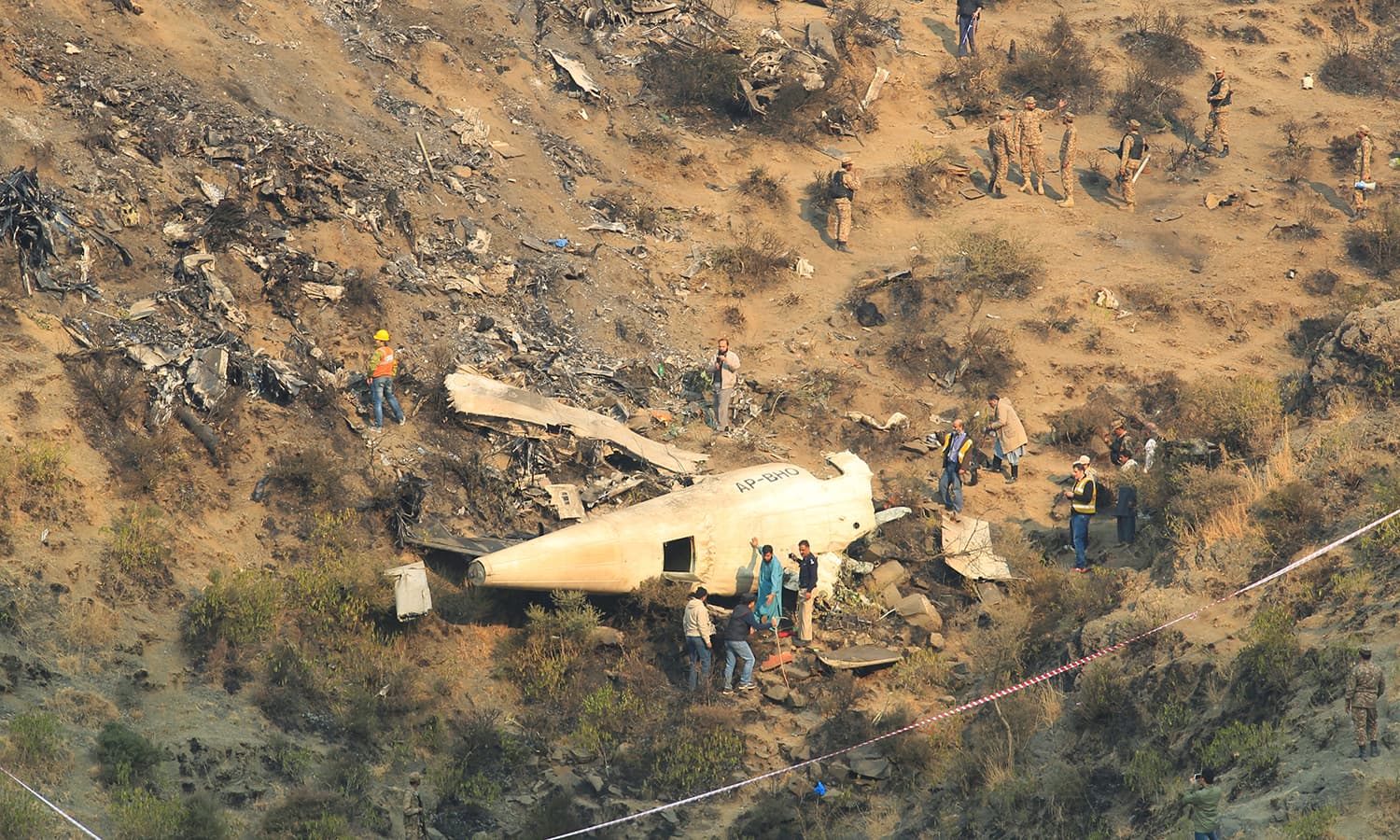 Rescue workers survey the site of the plane crash. ─Reuters