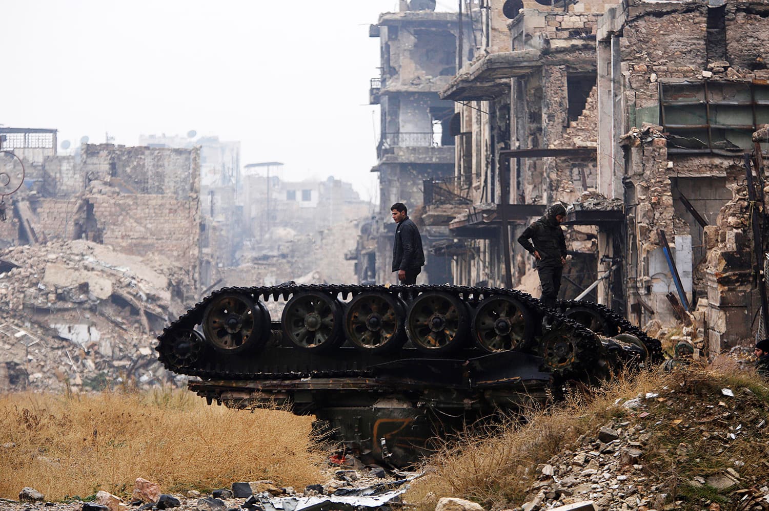 Forces loyal to Syria's President Bashar al-Assad stand atop a damaged tank near Umayyad mosque, in the government-controlled area of Aleppo, during a media tour, Syria December 13, 2016. ─ Reuters