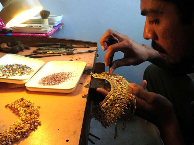 A goldsmith prepares a necklace at his workshop in Karachi.—AFP/file