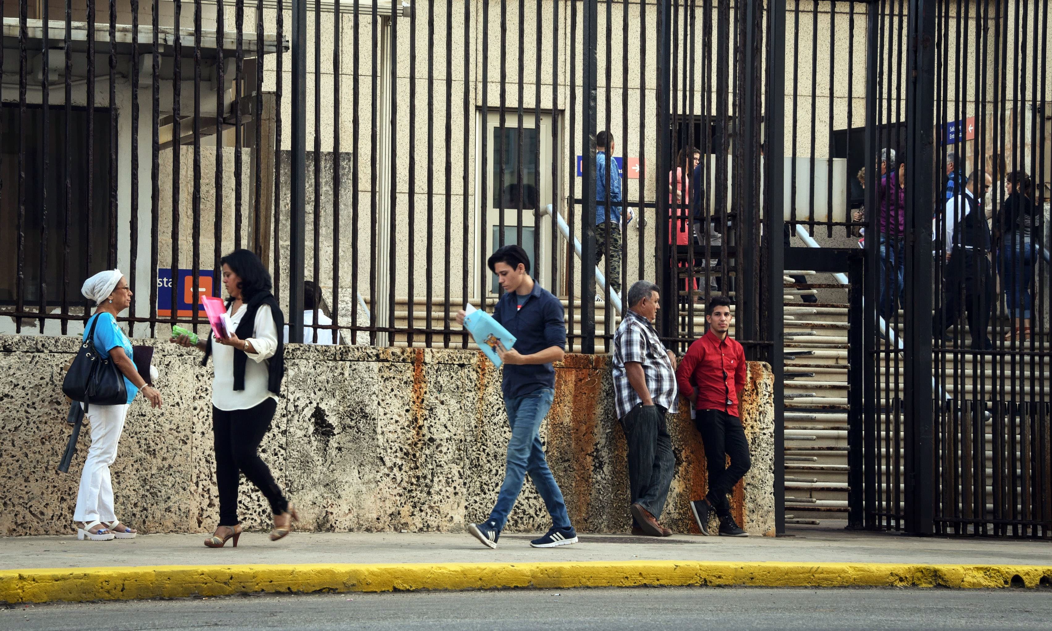 Cubans walk near US Embassy in Havana. —AFP