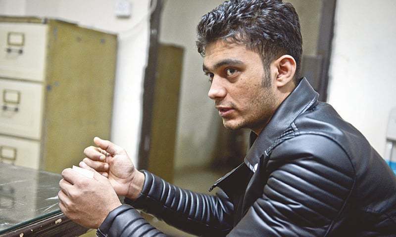 ایف آئی اے کے انسداد انسانی اسمگلنگ ونگ کے کراچی دفتر میں موجود نوجوان محمد اشفاق&mdash;۔فوٹو/ ڈان