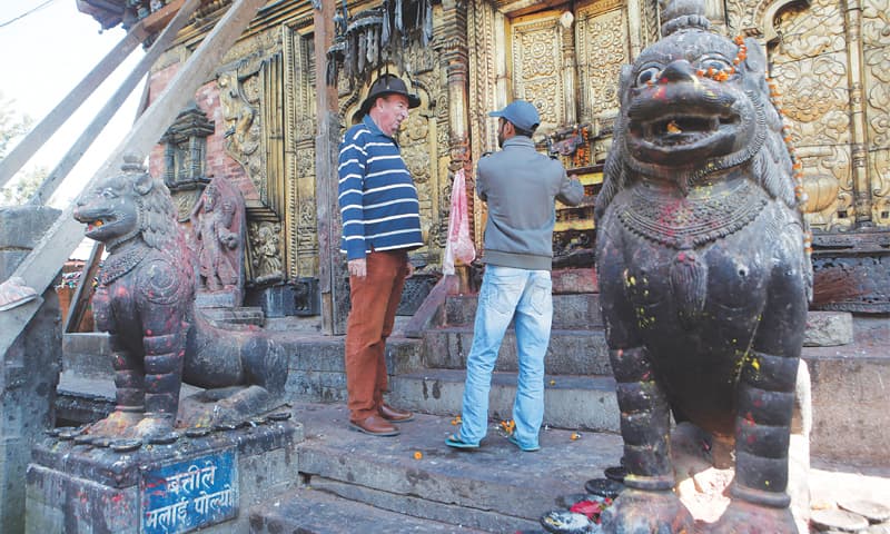 British architect John Sanday speaks to Anish Bhatta, whose family has been living and leading worship at Changu Narayan temple for 10 generations, in front of the temple dedicated to Lord Vishnu, at Changu village, 20 kilometres east of Kathmandu, Nepal.&mdash;AP
