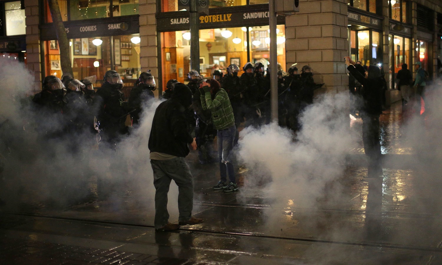 مظاہرین کی جانب سے پتھر اور خالی بوتلیں پھینکے جانے پر پولیس نے آنسو گیس کی مدد سے احتجاج کرنے والے افراد کو روکنے کی کوشش کی—فوٹو:اے پی