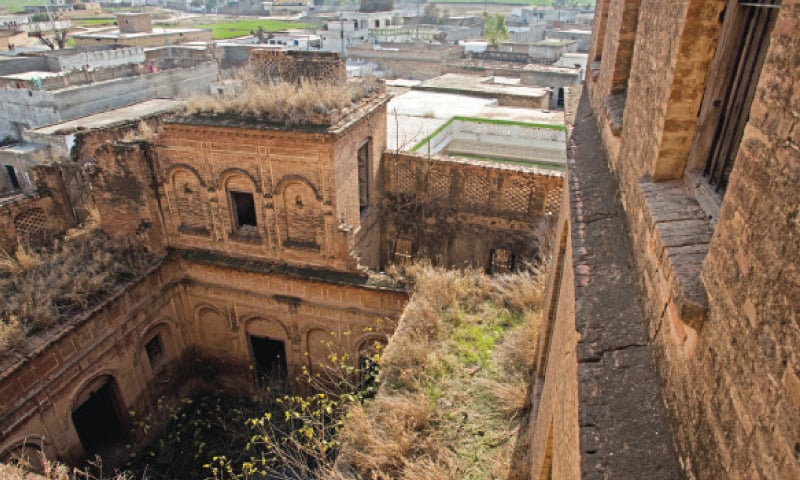 The crumbling structure has been encircled by other buildings.
