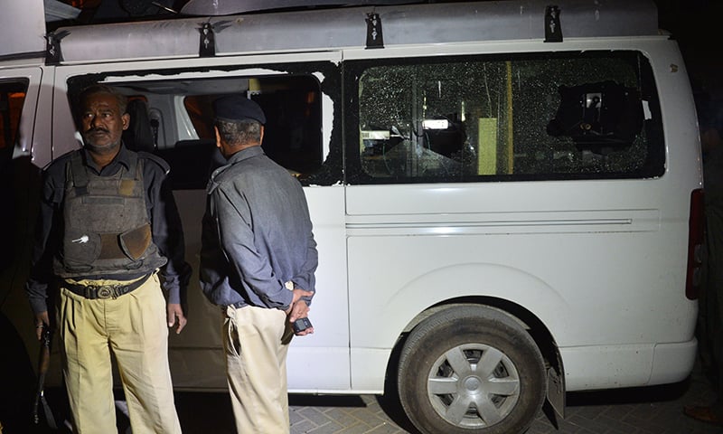 Police stand next to a damaged TV news channel van after an assault on Feb 12.— AFP