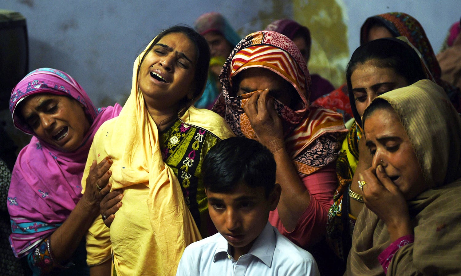 A Pakistani mother mourns along with others over the coffin of her 13-year-old blast victim Zeeshan during his funeral in the town of Sehwan.─AFP