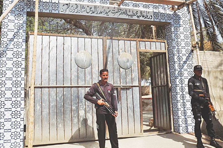TWO security officials stand guard at the shrine of Syed Sadruddin Shah Badshah, which was also sealed, in Sukkur on Friday.&mdash;Online