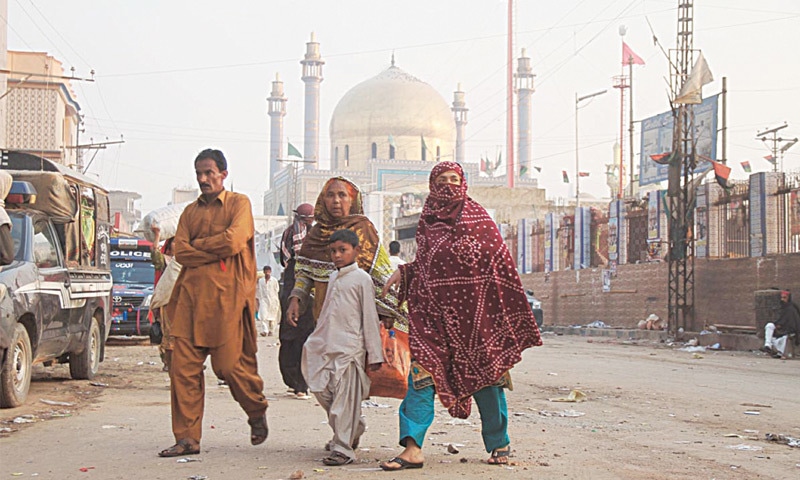 A FAMILY walks past the Qalandar&rsquo;s dargah on Friday.&mdash;Online
