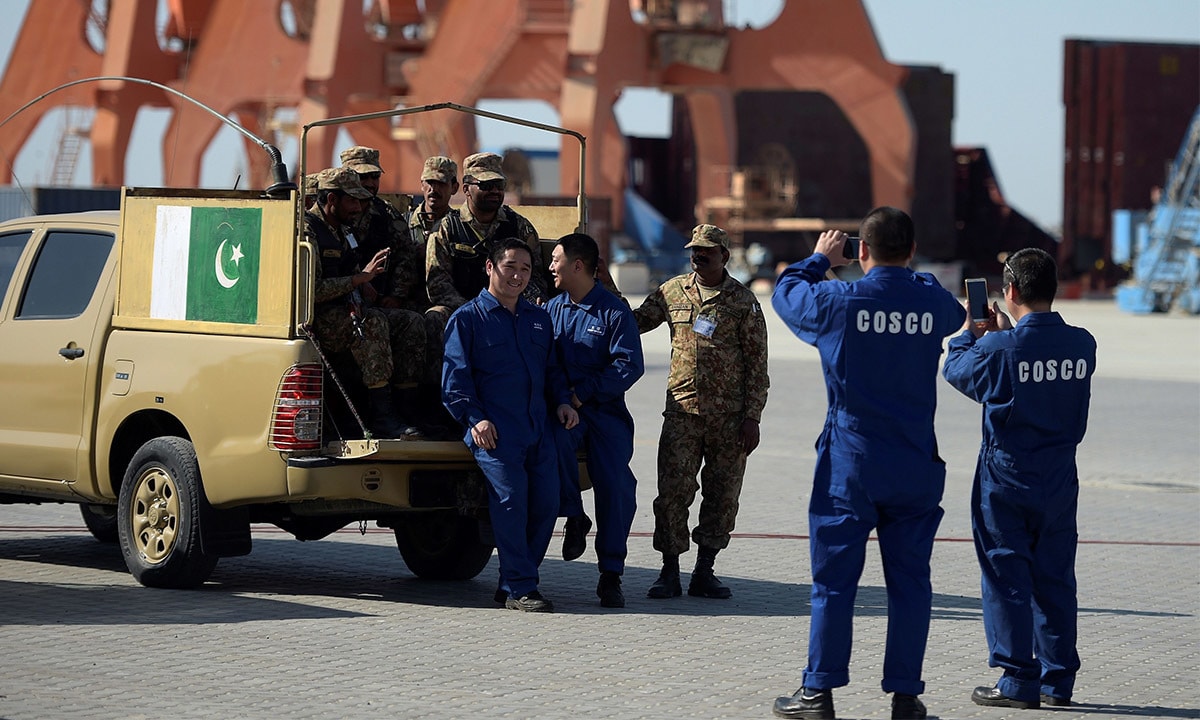 Crew members of a Chinese ship take pictures with Pakistani security officials in Gwadar |AFP