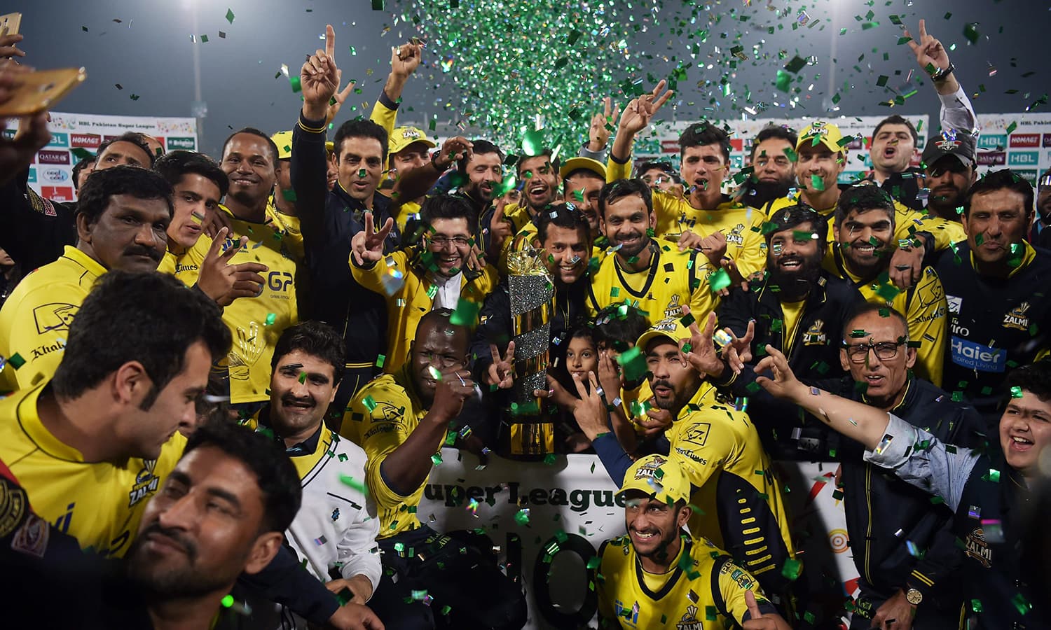 Cricketers of Peshawar Zalmi their victory over Quetta Gladiators in the final cricket match of the Pakistan Super League (PSL) at The Gaddafi Cricket Stadium in Lahore on March 5, 2017. / AFP PHOTO / AAMIR QURESHI — AFP or licensors