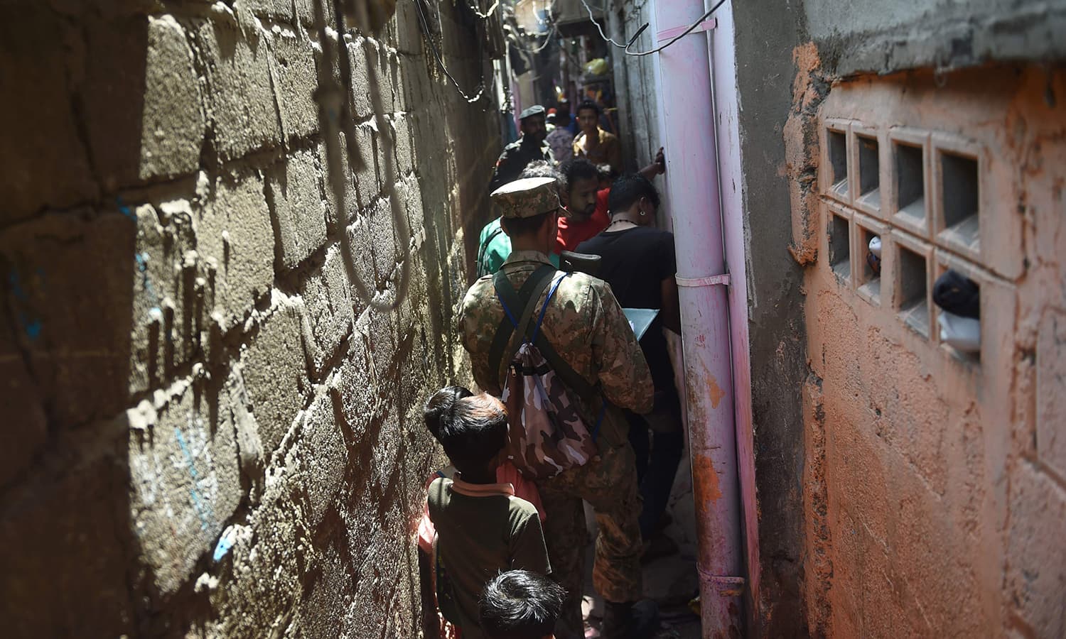 Officials from the Pakistan Bureau of Statistics collect information from residents during a census in a narrow street in Karachi. — AFP