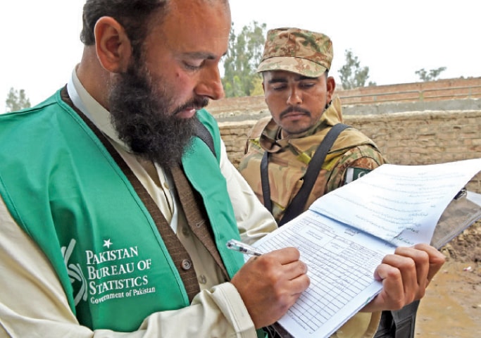 An enumerator notes the particulars of a family in Peshawar during the national census that started across the country on Wednesday. &mdash; Photo by Abdul Majeed Goraya