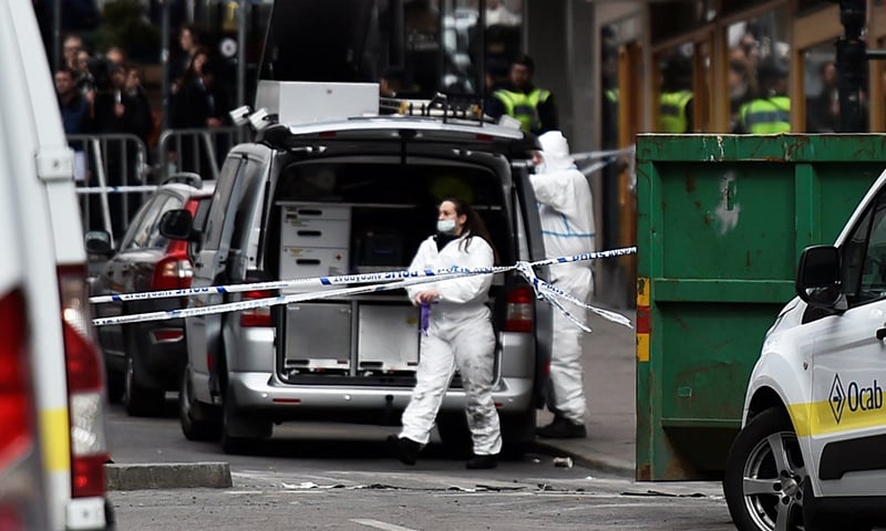 Forensic police investigators work at the crime scene in central Stockholm. -Reuters