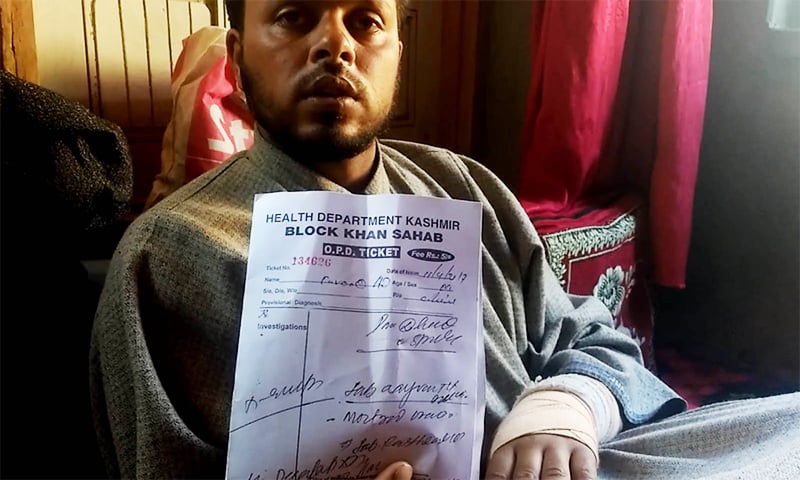 Farooq Dar displays his medical report. ─ Photo by Rayan Naqash