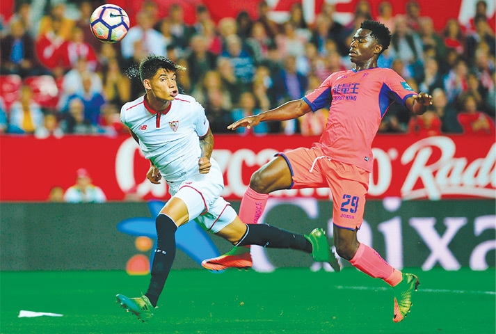 SEVILLE: Joaquin Correa (L) of Sevilla heads the ball past Granada&rsquo;s Martin Hongla during their La Liga match at the Ramon Sanchez Pizjuan Stadium.&mdash;AFP