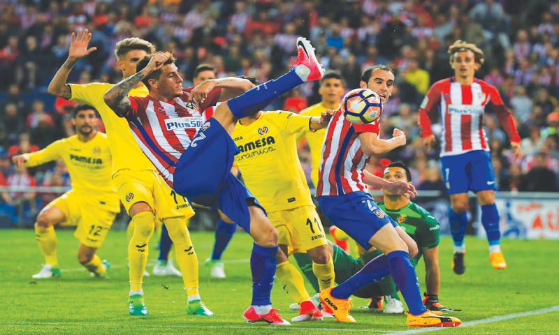 MADRID: Atletico Madrid’s Jose Maria Gimenez (third L)clears the ball during the La Liga match against Villarreal at the Vicente Calderon Stadium.—Reuters