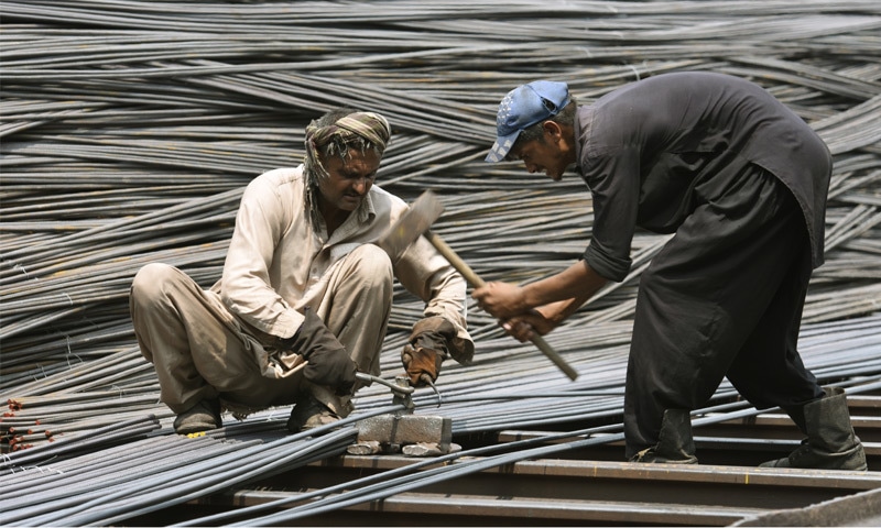 Workers cut iron rods outside a steel manufacturing facility in this file photo.—White Star Workers cut iron rods outside a steel manufacturing facility in this file photo.—White Star