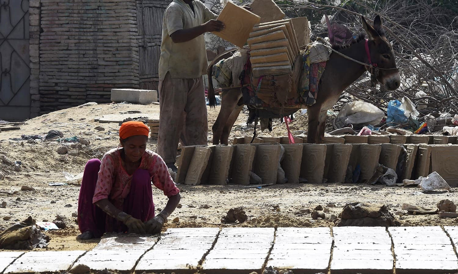 Labourers make bricks at a factory in Karachi. -AFP