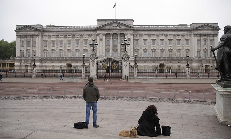 People face Buckingham Palace, in London, May 4.─AP