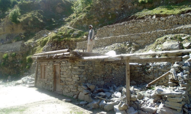 A man stands at a dilapidated school built by locals after it was destroyed in 2010 floods in Kandia area of Kohistan. &mdash;Dawn