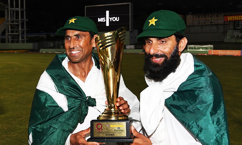 Younis Khan and captain Misbah ul Haq celebrate with the series trophy  after winning the final test match and the series 2-1 against the West Indies at the Windsor Park Stadium in Roseau, Dominica — AFP