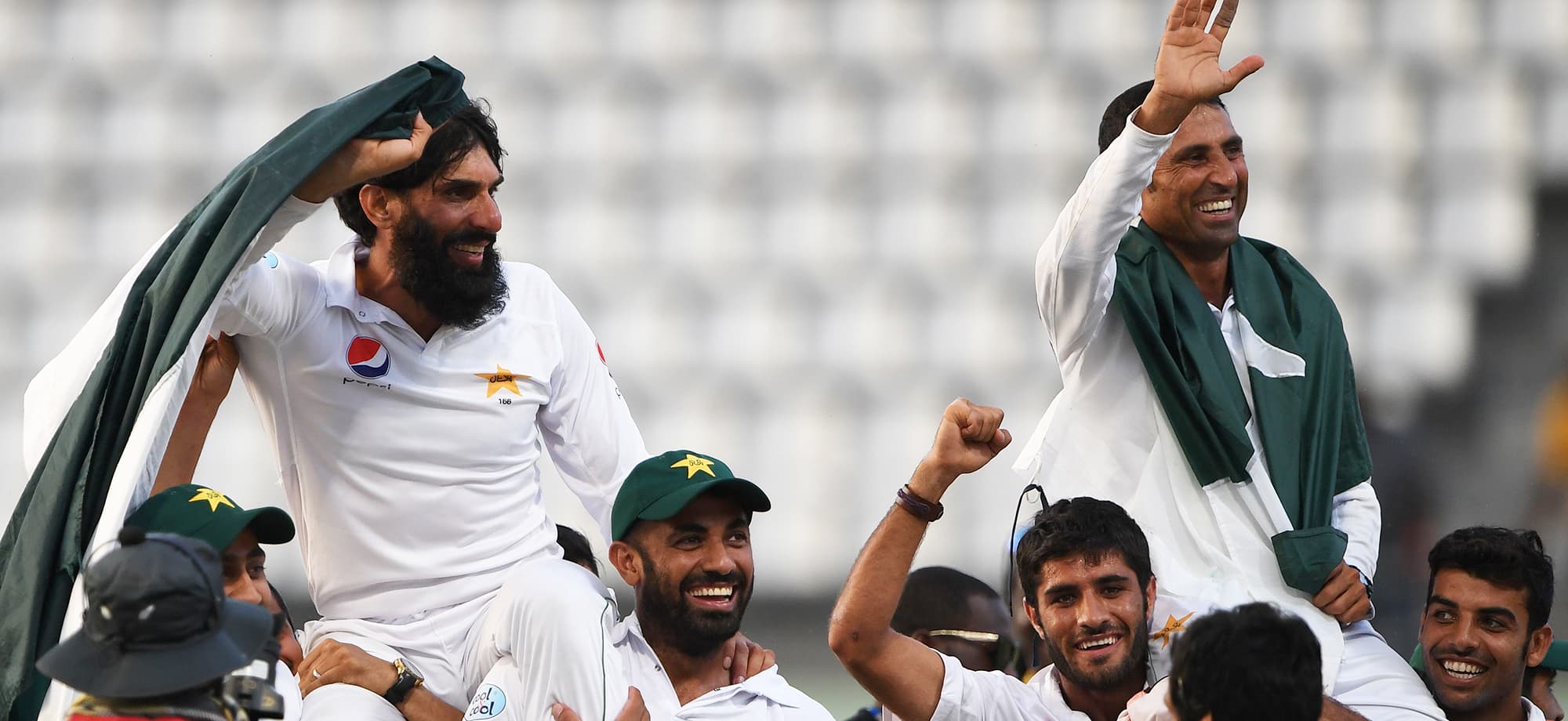 Retiring Pakistan cricket team members captain Misbah-ul-Haq (L) and Younis Khan (R) are carried by teammates as they celebrate after winning the final test match and the series 2-1 against the West Indies at the Windsor Park Stadium in Roseau, Dominica on May 14, 2017. / AFP PHOTO / Mark RALSTON — AFP or licensors