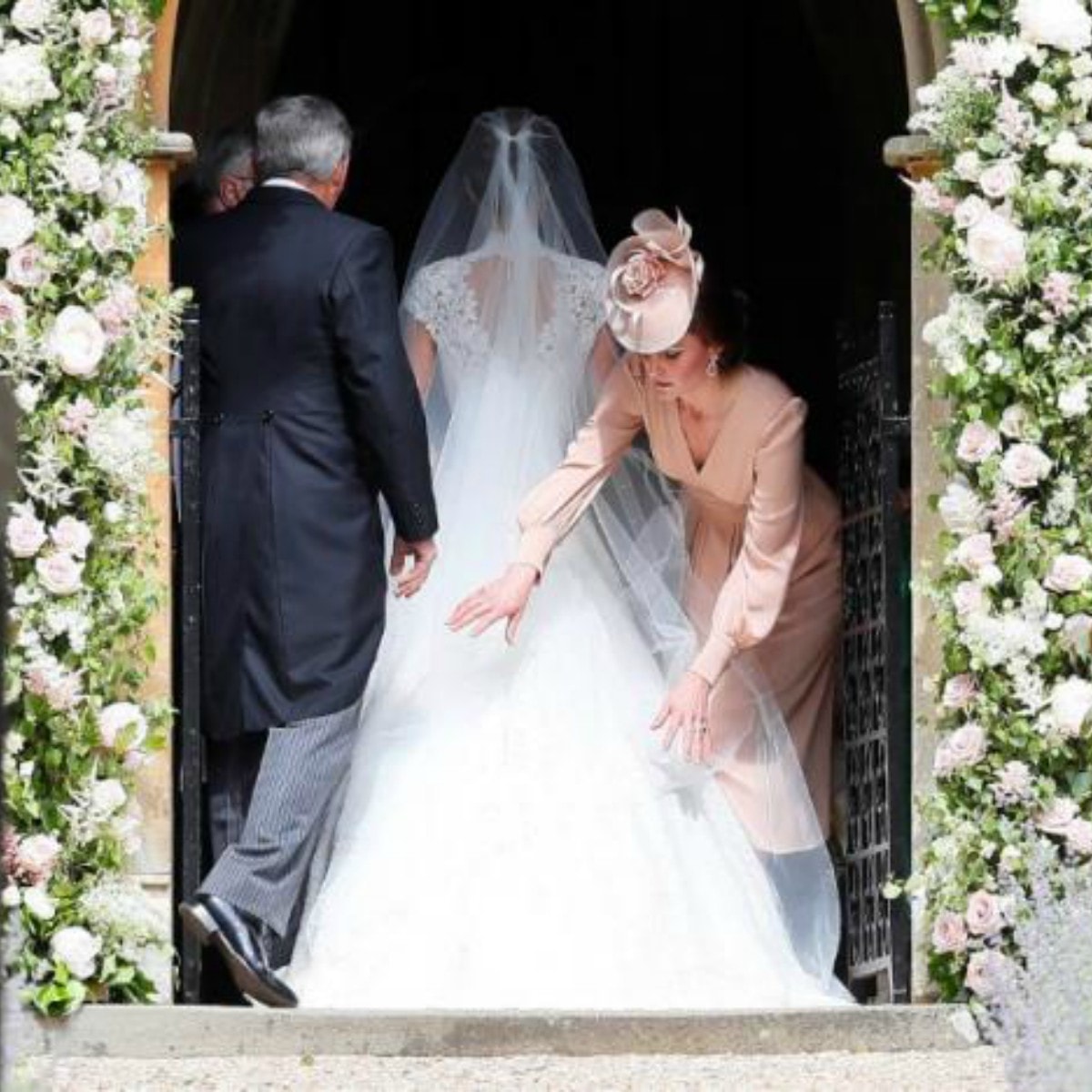 Duchess of Cambridge Kate adjusts the train of Pippa's dress as she enters St. Mark's Church — Reuters