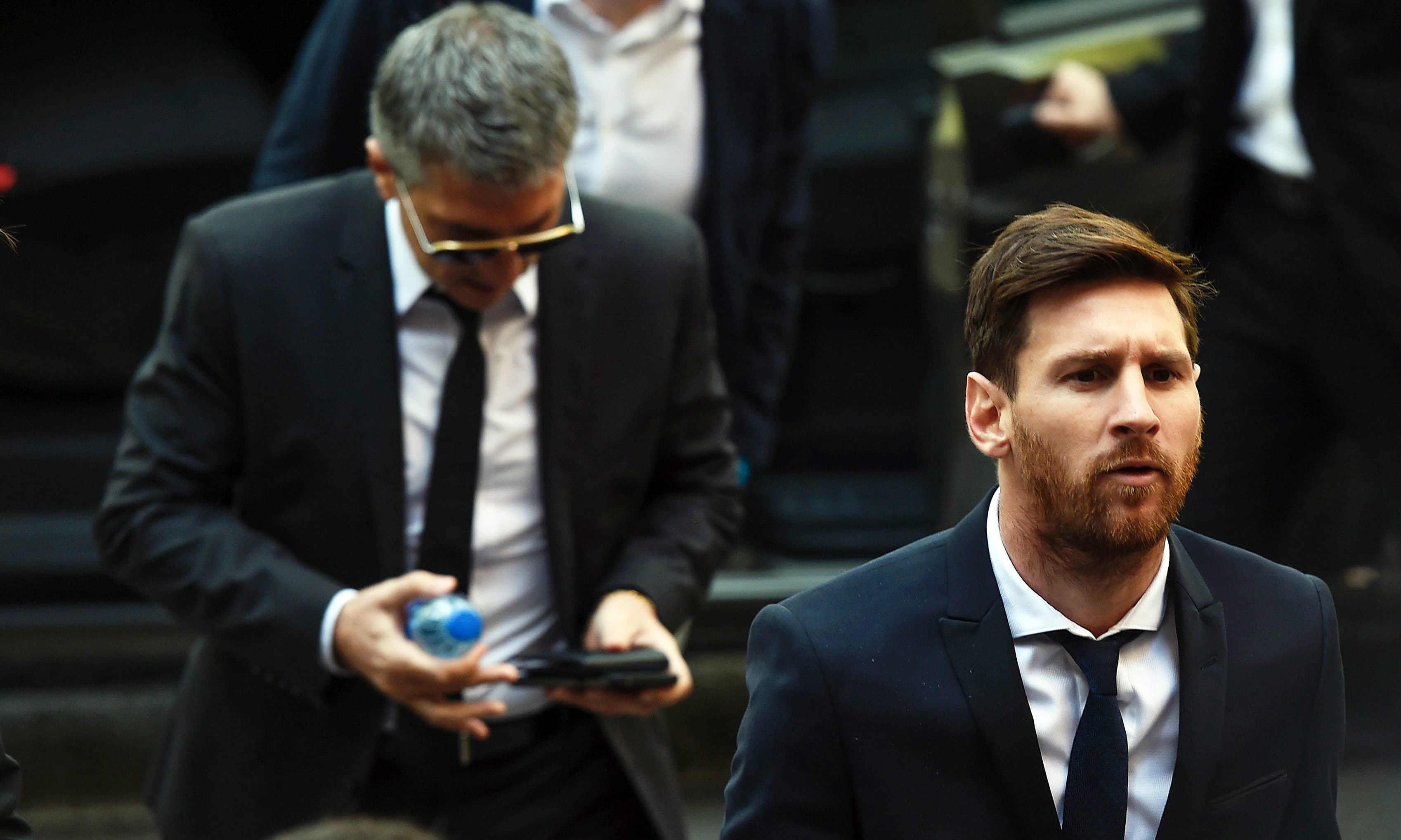 Lionel Messi followed by his father Jorge Horacio Messi arriving at the courthouse. &mdash;AFP/File