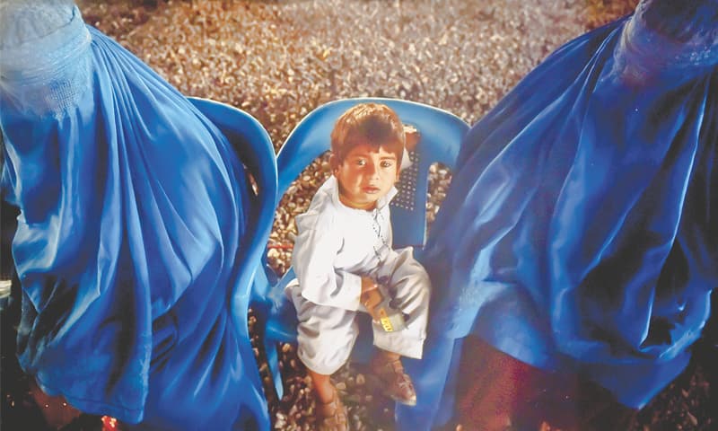 An Afghan refugee family sitting at the UNHCR registration centre on the outskirts of Peshawar before their departure to their home country.