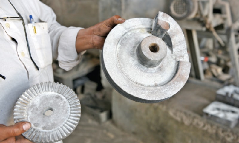 A worker holds the final product. — Photos by Tanveer Shahzad