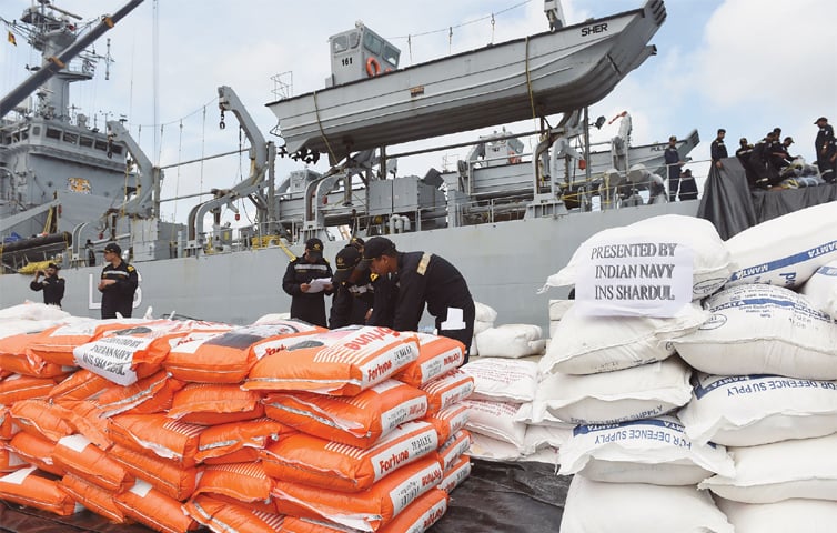 Indian Navy troops offload emergency supplies from an Indian ship at Colombo harbour.—AFP