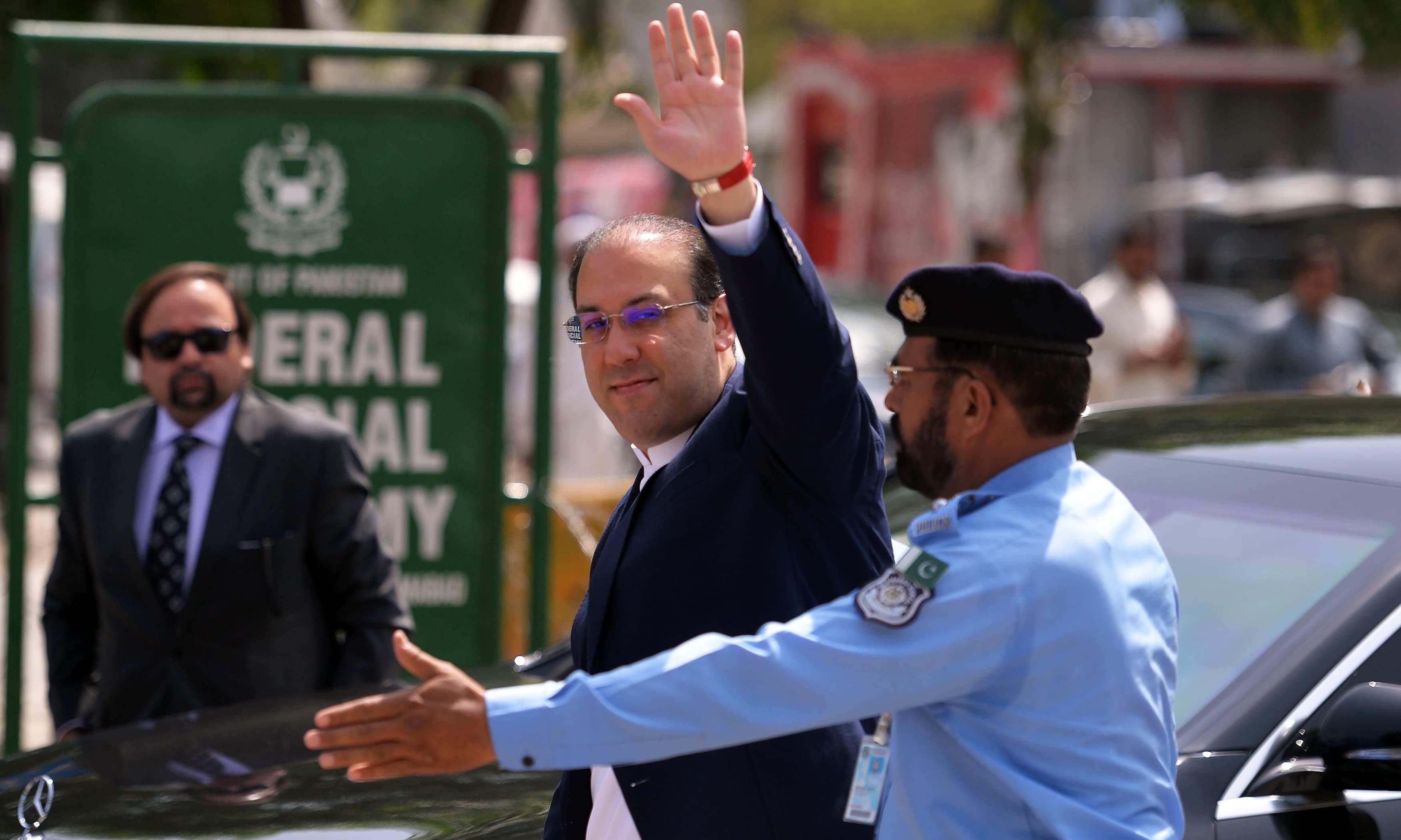 Hassan Nawaz waves as he arrives to record his statement before the JIT at the Federal Judicial Academy in Islamabad. —AFP