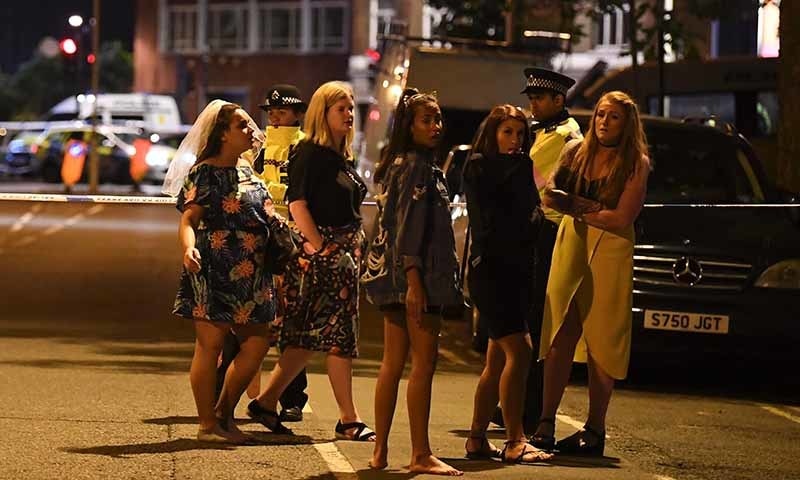 Women stand at a police cordon set up in London.─AFP