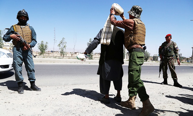 Afghan security soldiers search a man at a checkpoint, ahead of Eidul Fitr.—AFP