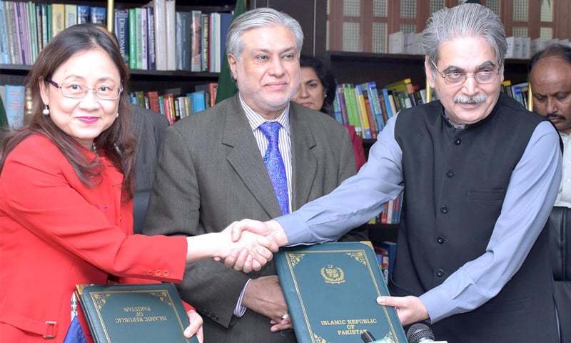 Then Secretary for Economic Affairs Division Tariq Mahmood Pasha (R) and ADB Country Director for Pakistan Xiaohong Yang exchange documents after signing a loan agreement earlier this year.—APP/File