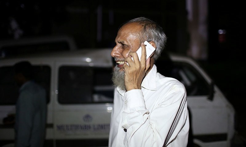 بوائلر حادثے میں جاں بحق ہونے والی ایک خاتون کے سسر روتے ہوئے کسی سے فون پر بات کر رہے ہیں&mdash;۔فوٹو/ رائٹرز