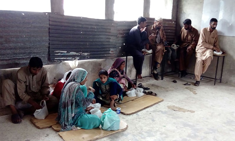 Families from Azad Jammu and Kashmir take shelter in a state-run school in Abbaspur city on Monday after fleeing their village along the LoC because of cross-border shelling by Indian troops.— AFP