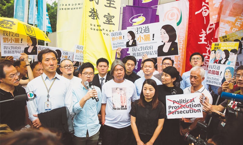 Hong Kong: Pro-democracy lawmakers Edward Yiu Chung-yim (second left), Nathan Law (third left), Leung Kwok-hung, also known as &ldquo;long hair&rdquo; (centre), and Lau Siu-lai (centre right) speak to media on Friday before the verdict was handed down.&mdash;AFP