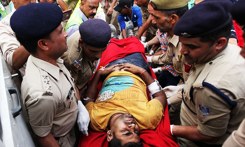 An Indian pilgrim injured in a bus crash is carried on strecther into the government medical college in Jammu.—AFP