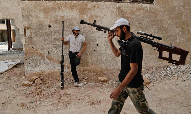 Syrian rebel fighters from the Faylaq al-Rahman brigade carry their homemade 12.7mm sniper rifle in Ain Tarma, in the eastern Ghouta area, a rebel stronghold east of the capital Damascus.─AFP Syrian rebel fighters from the Faylaq al-Rahman brigade carry their homemade 12.7mm sniper rifle in Ain Tarma, in the eastern Ghouta area, a rebel stronghold east of the capital Damascus.─AFP