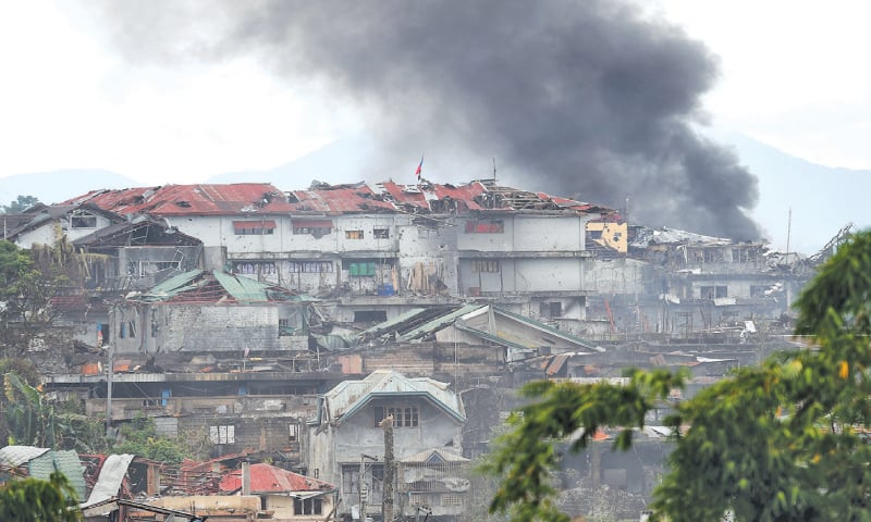 MARAWI: Black smoke billows from burning after an aerial bombing by Philippine Air Force attack helicopters at militant positions on Saturday.─AFP